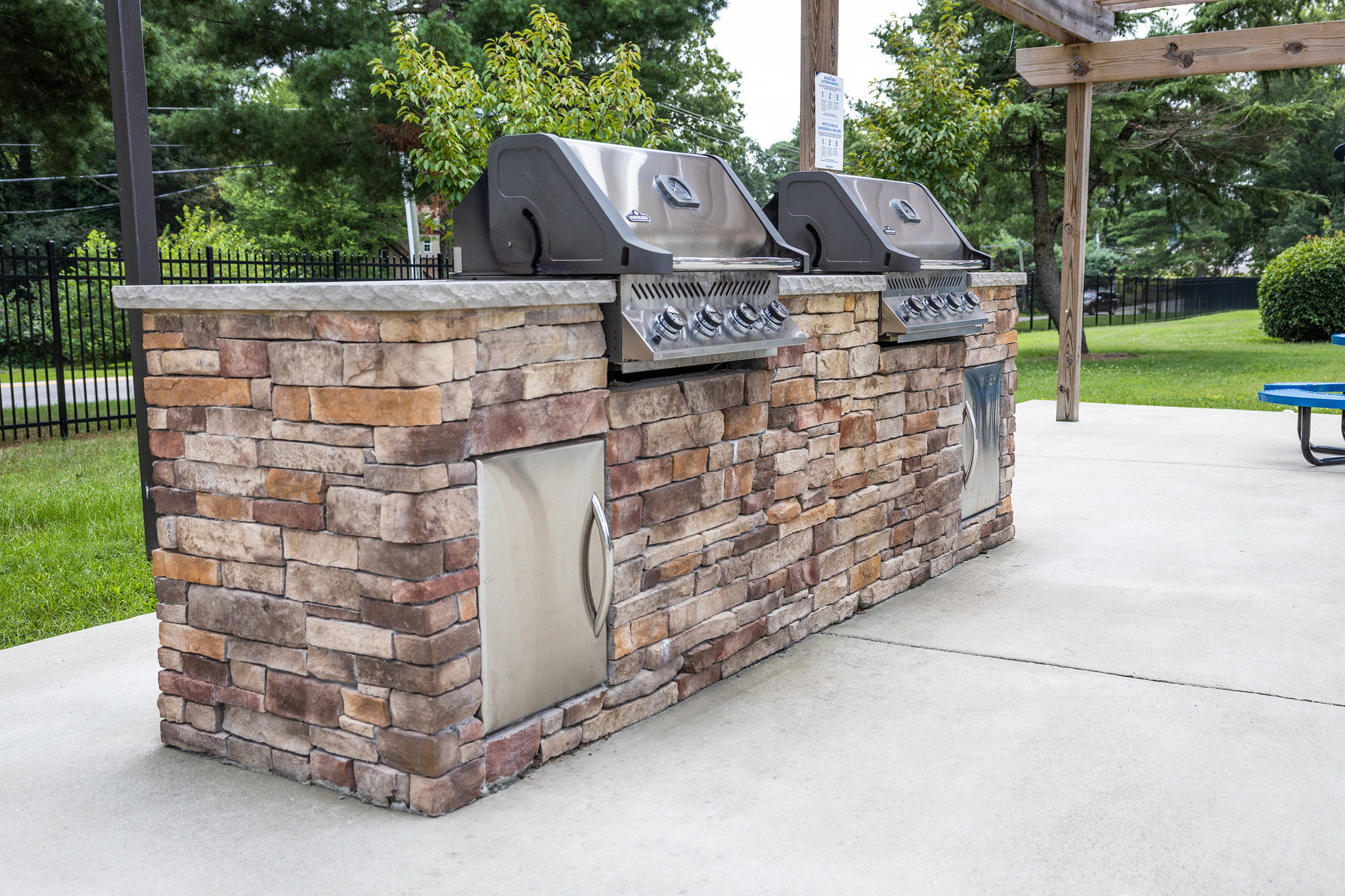 a brick outdoor kitchen with two bbq grills